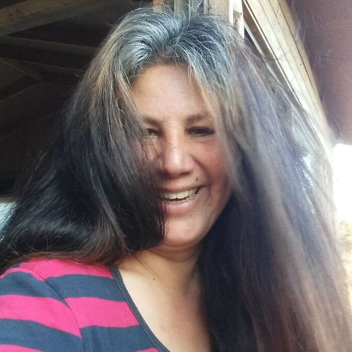 A smiling woman with long hair standing indoors, dedicated to creating a sanctuary for nearly 200 homeless dogs. A smiling woman with long hair standing indoors, dedicated to creating a sanctuary for nearly 200 homeless dogs.