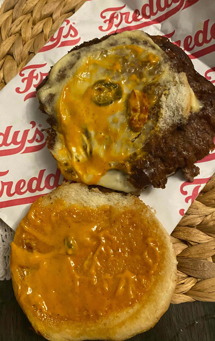 Overly sauced burger with melted cheese and jalapenos, one of the outrageous meals that looked nothing like menu photos.
