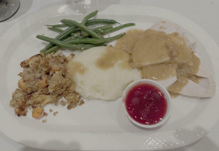 Thanksgiving meal with mashed potatoes, green beans, stuffing, turkey, and cranberry sauce, an example of outrageous meals.