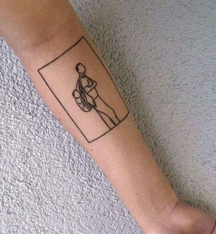 Minimalist tattoo of two people inside a rectangle on forearm, showcasing wholesome tattoos with meaningful little ink design.