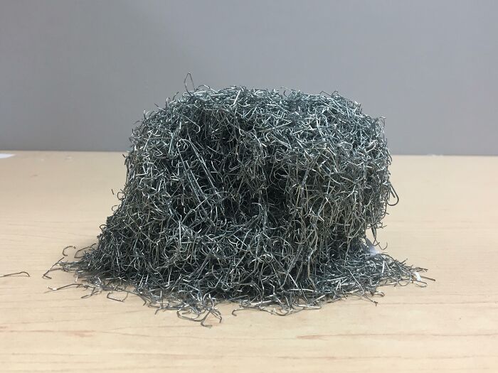 Close-up of tangled metal wire pile on wooden surface showing unique work materials in different jobs making a 9-to-5 more bearable