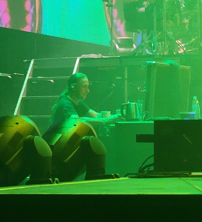 Person working backstage at a live event surrounded by stage equipment and lighting in a unique 9-to-5 job environment.