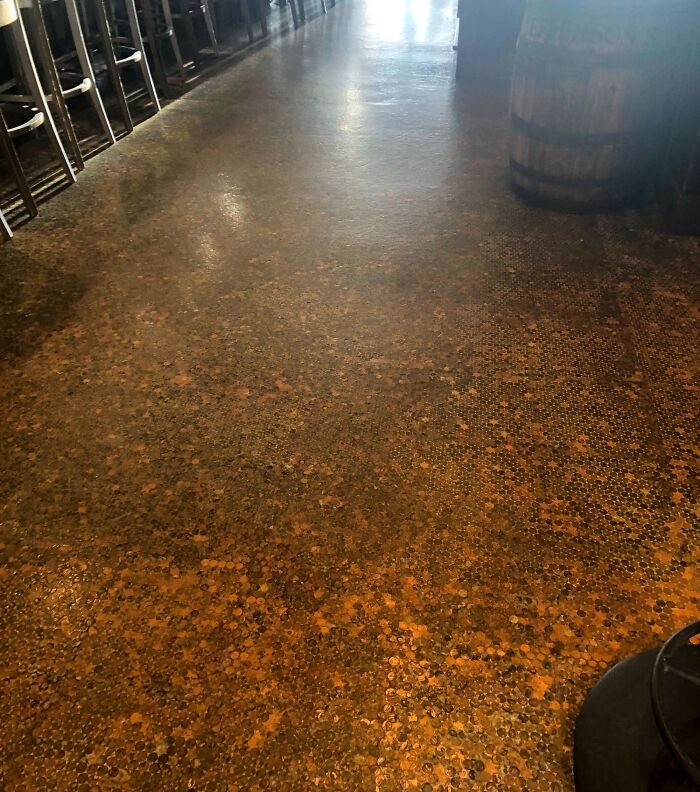 Floor made entirely of pennies in a bar showcasing a creative job that makes a 9-to-5 workday more bearable.