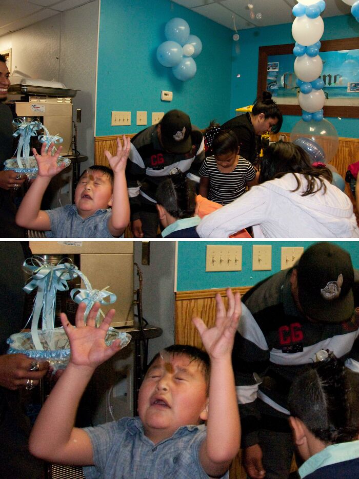 Boy at a party with eyes closed and hands raised as a chocolate piece is perfectly captured mid-air on his face.