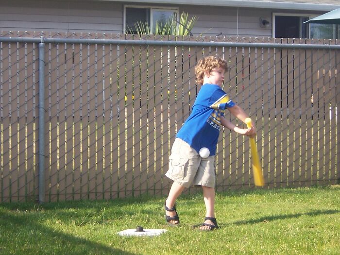 Boy swinging a bat with the ball caught perfectly mid-air in this funny and interesting pics taken at the perfect time.