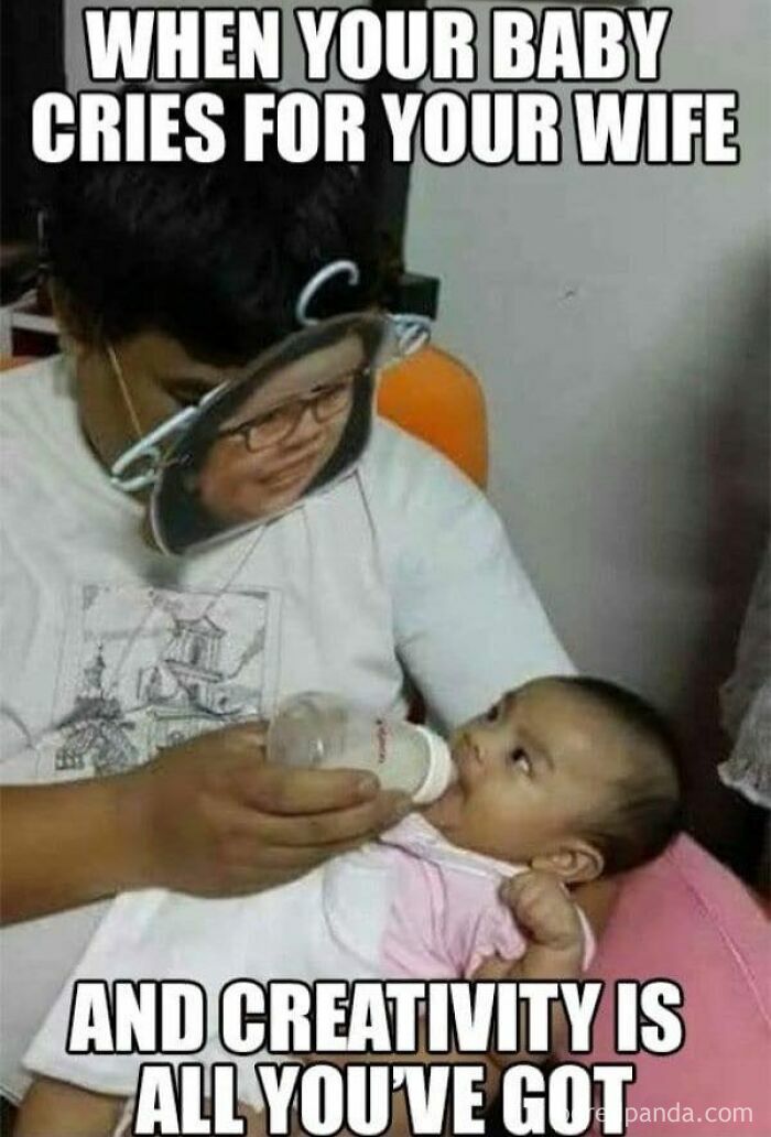 Parent feeding baby with a creative mask to soothe them, capturing relatable memes for parents going through challenging moments.