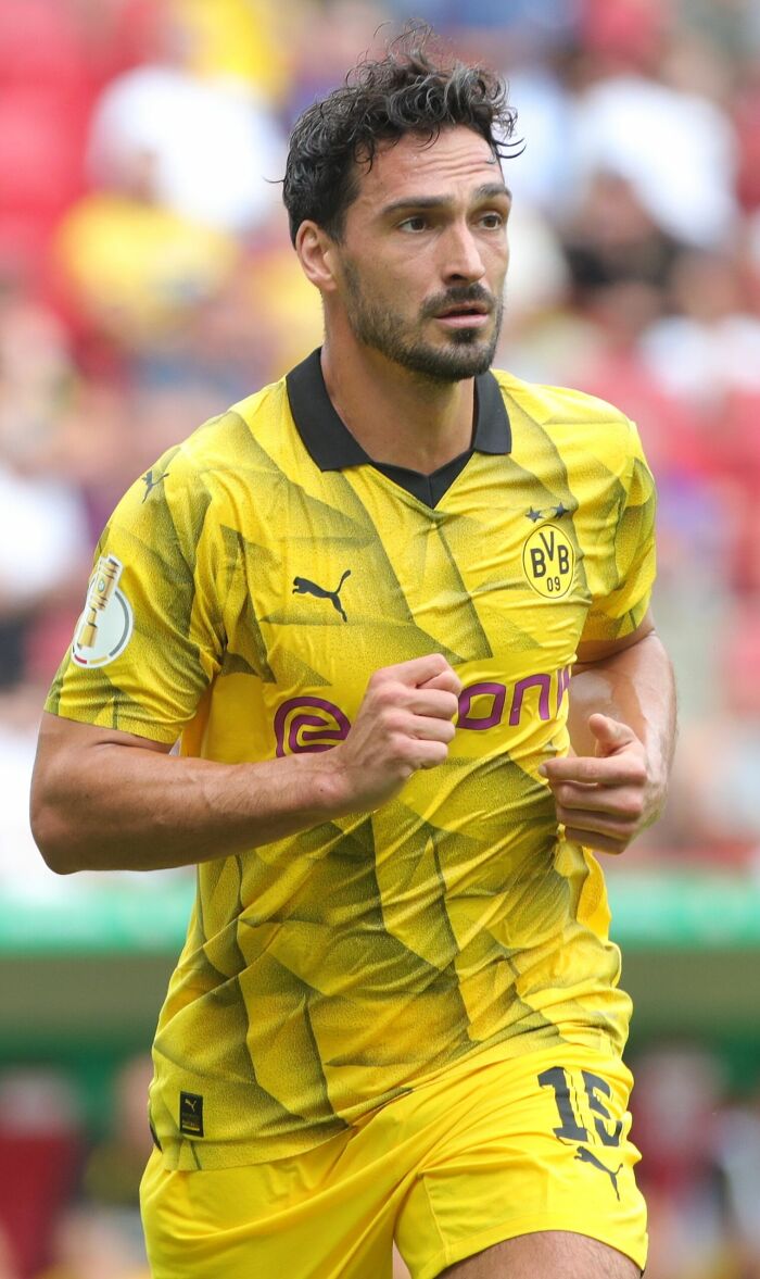 Mats Hummels in Borussia Dortmund yellow jersey during a football match, showing focus and determination on the field