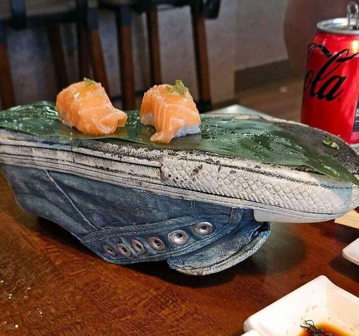 Sushi served on a worn sneaker with a leaf, showcasing one of the most ridiculous ways food is served in restaurants.