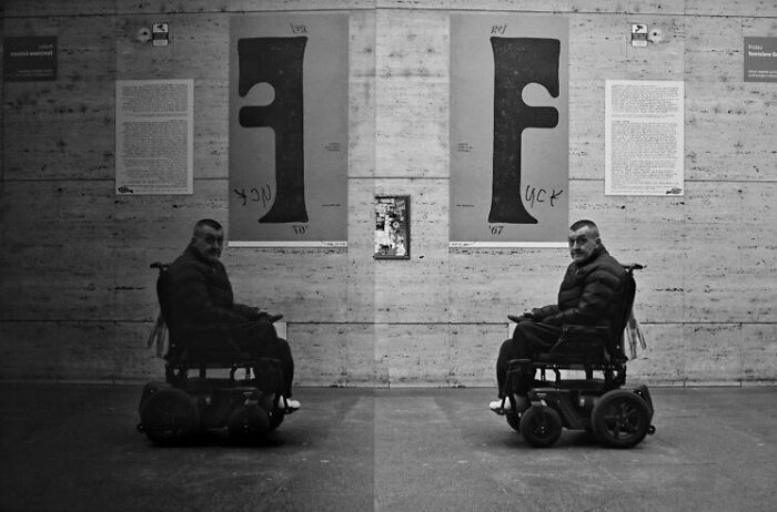 Man in wheelchair in an urban setting, capturing street moments that reflect the marvels of daily life.