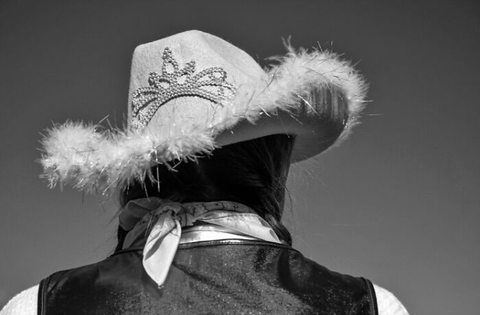 Person wearing a decorative hat and scarf, capturing a street moment that feels like magic in daily life.