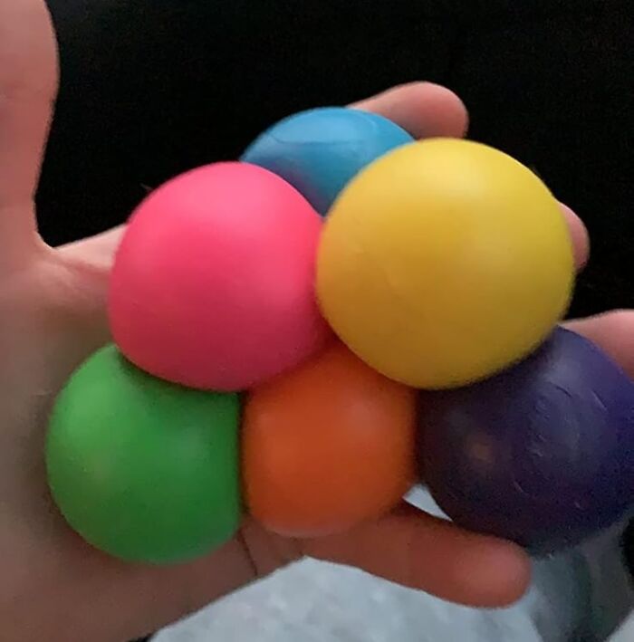 Hand holding colorful stress relief balls, a creative last-minute gift idea for unexpected guests.