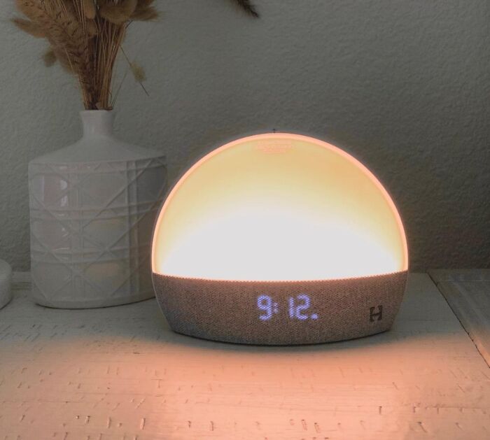 Smart sunrise alarm clock glowing warmly on a table, ideal as gifts for last-minute guests during the holidays.
