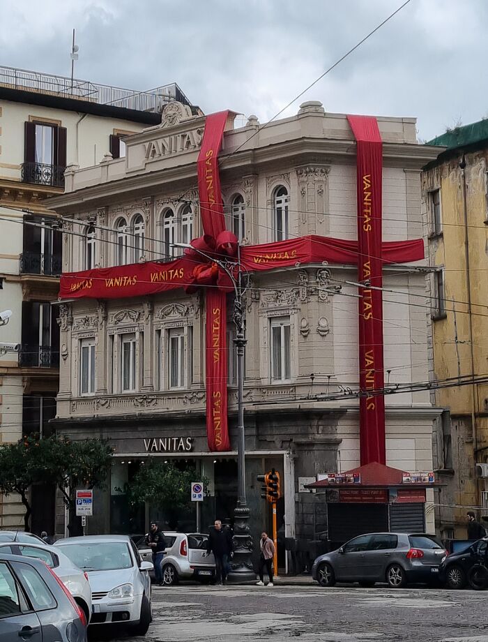 Historic building wrapped with giant creative Christmas decorations in a busy urban workplace setting.
