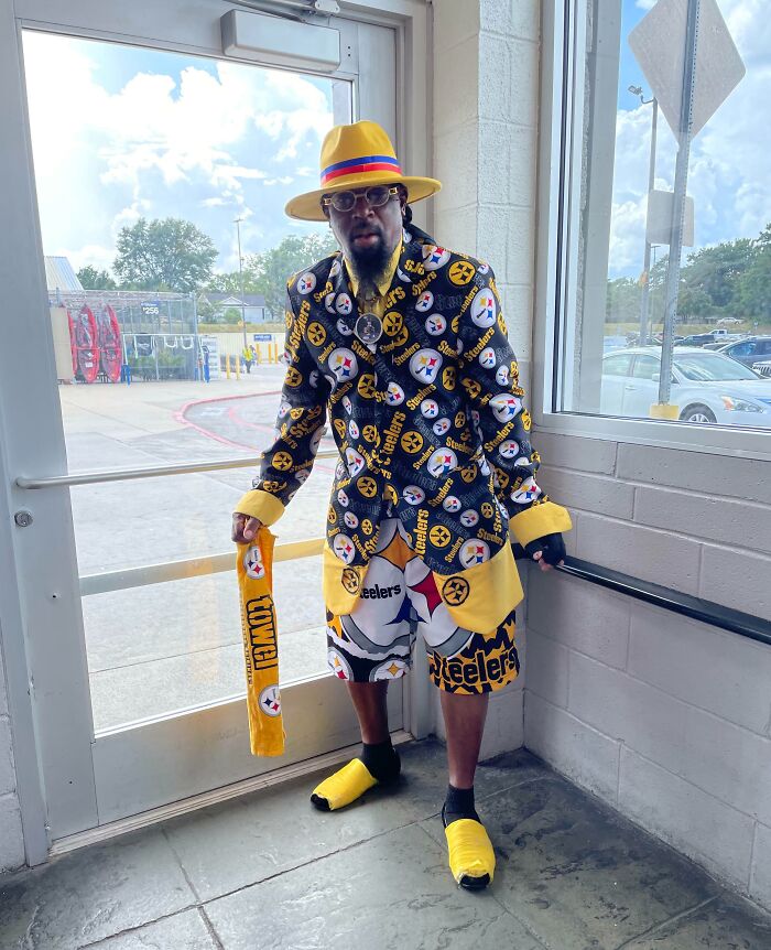 Man dressed in Pittsburgh Steelers outfit standing inside a Walmart store near the entrance door.