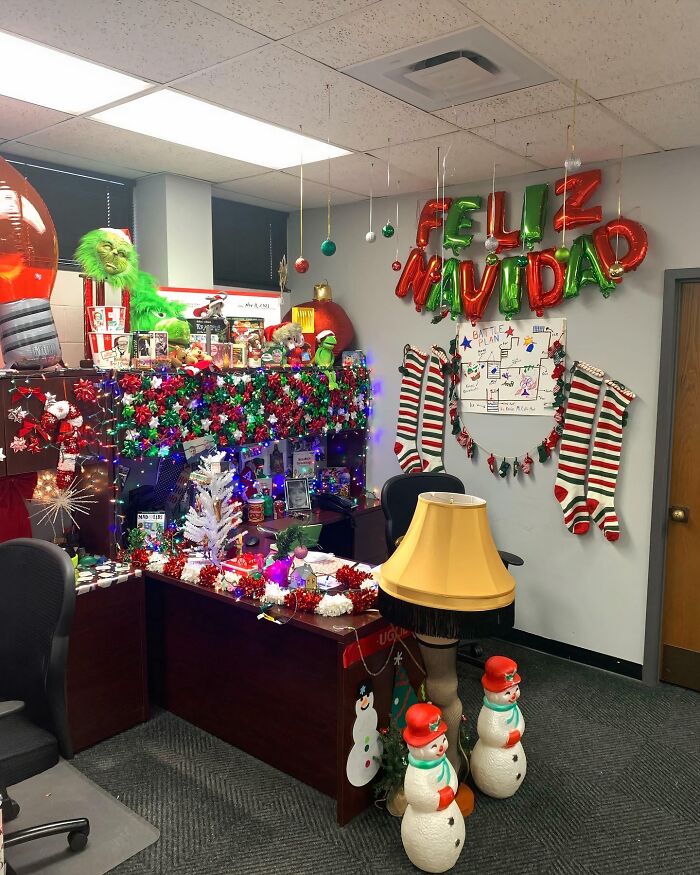 Creative workplace Christmas decorations with colorful lights, stockings, festive balloons, and holiday characters impressing Santa.