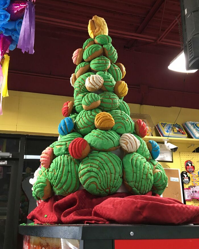 Creative Christmas decorations at workplace featuring a unique tree made of colorful concha bread, impressing holiday visitors.