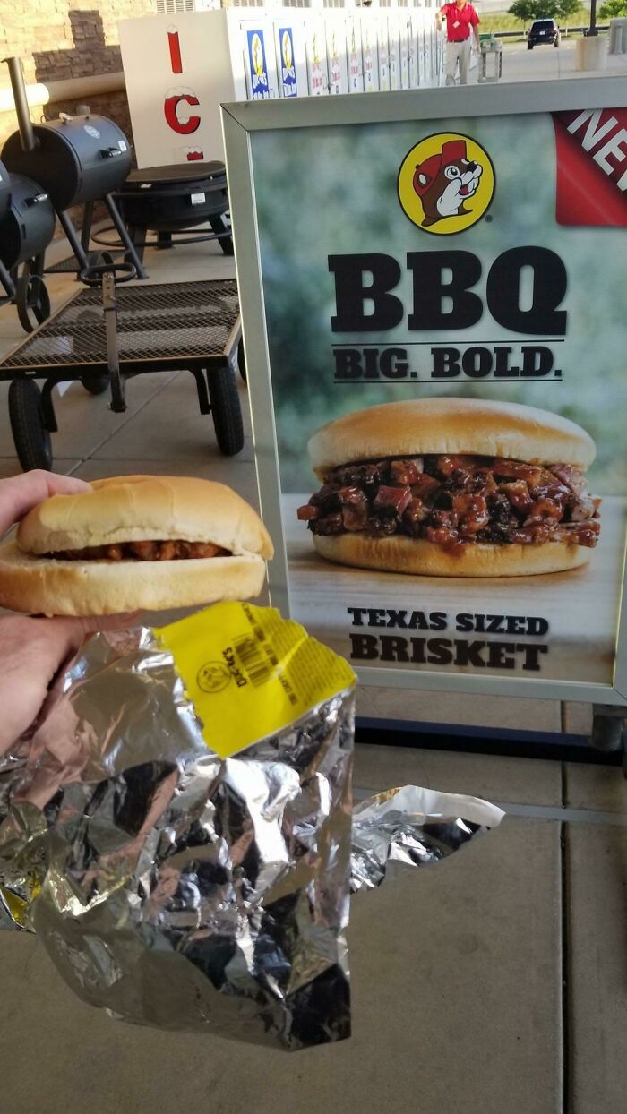 Hand holding small BBQ brisket sandwich wrapped in foil next to large expectation vs reality brisket sandwich photo.