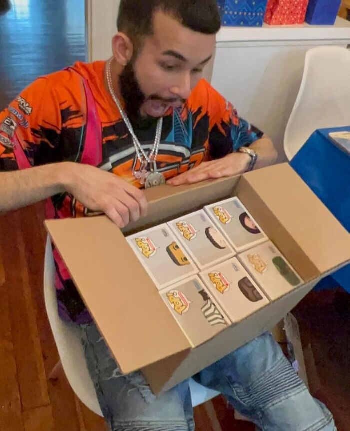 Man excitedly opening a box of blind boxes, showcasing surprise and anticipation in a high stakes game of chance.