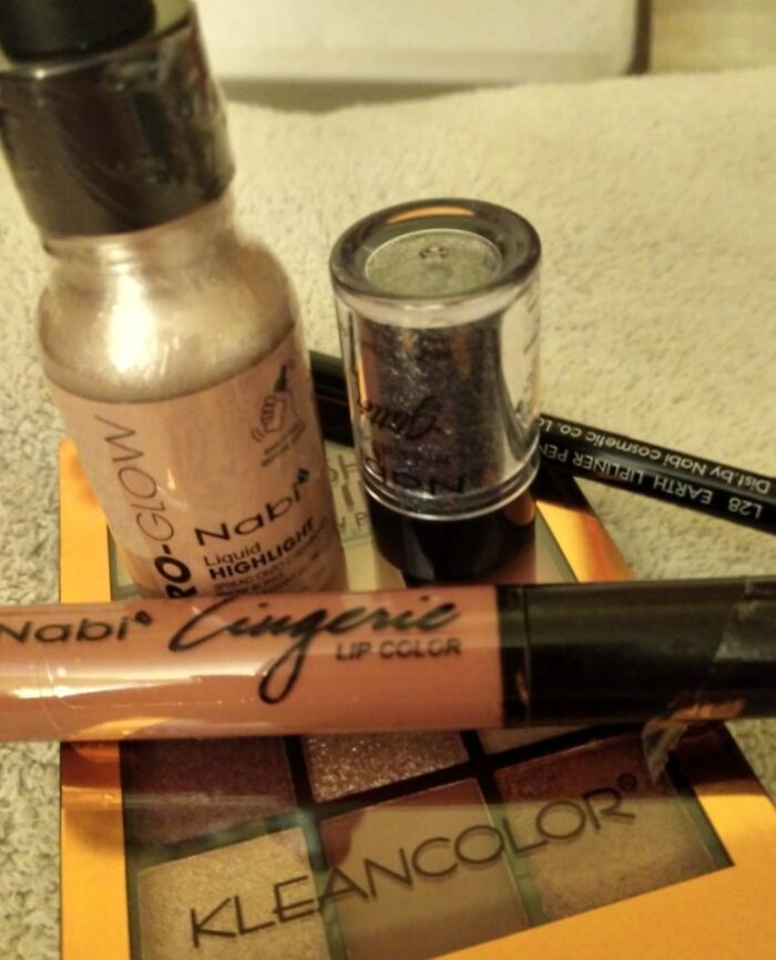 Makeup products including liquid highlighter, lip color, and eyeshadow palette, featured in blind boxes for Christmas chance game.