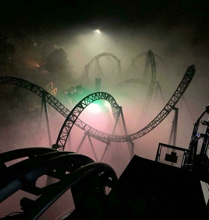Foggy roller coaster track bending in eerie, dim lighting, capturing the unsettling vibe of creepy liminal spaces like the Backrooms.
