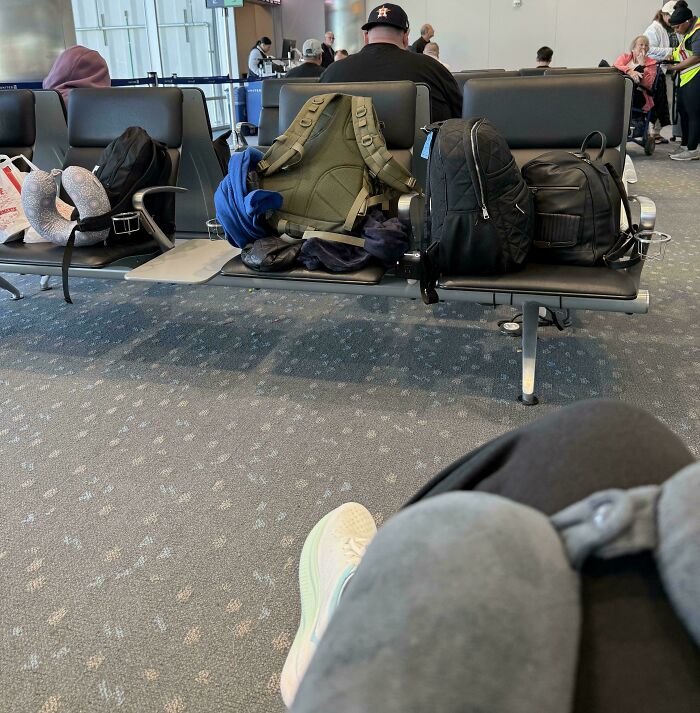 Backpacks and luggage taking multiple airport seats while traveler waits, next-level jerks.