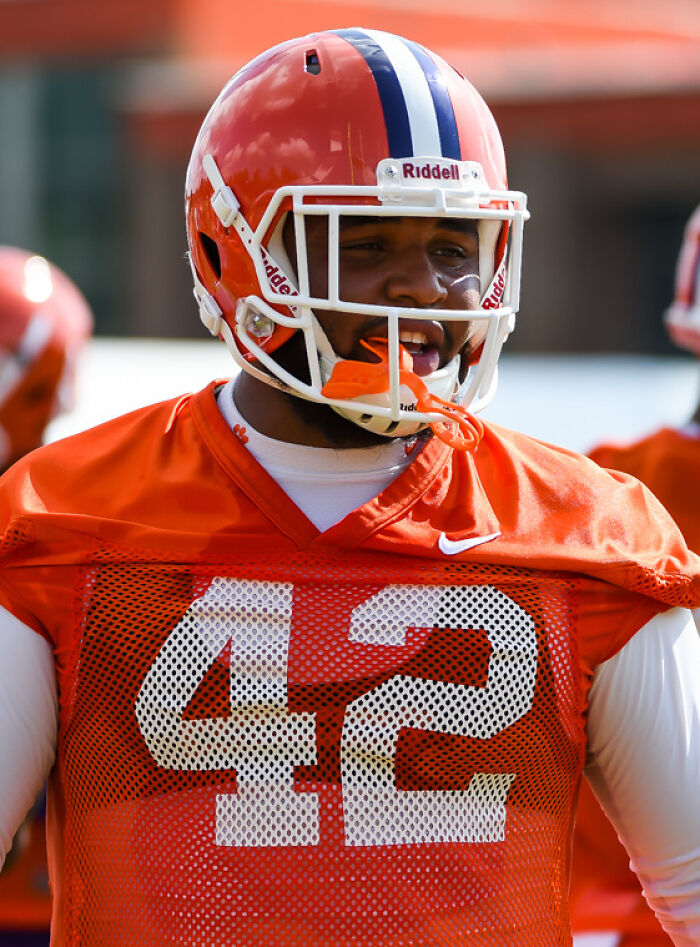 Football player wearing orange jersey number 42 and helmet during practice session, focusing on Christian Wilkins career highlights.