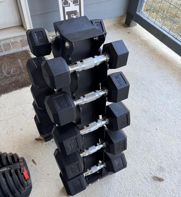 Stack of hex dumbbells on a rack outdoors, demonstrating apartment friendly fitness equipment for workout goals.
