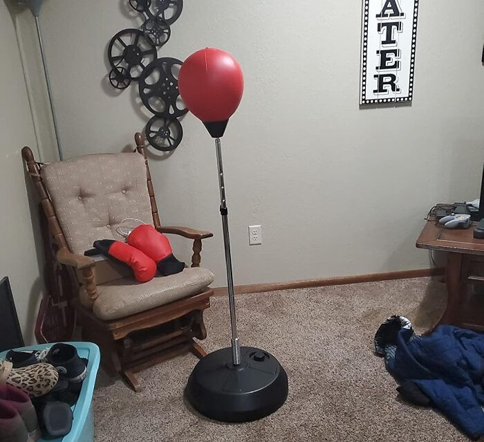Apartment friendly boxing setup with red gloves and a freestanding punching bag in a cozy living room corner.