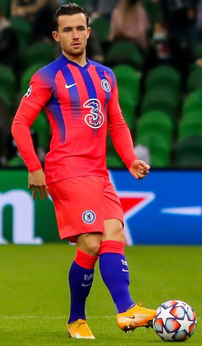 Ben Chilwell in Chelsea football kit controlling the ball during a match on the soccer field.