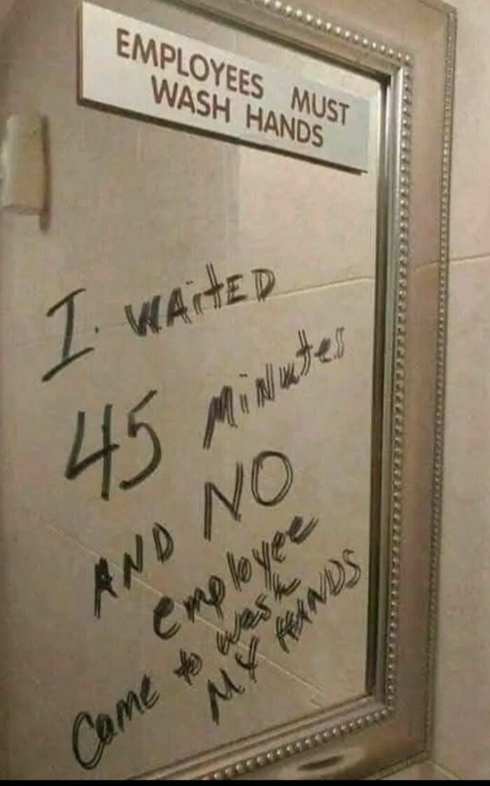 Bathroom mirror with a humorous handwritten message about waiting 45 minutes and no employees washing hands, funny memes concept.