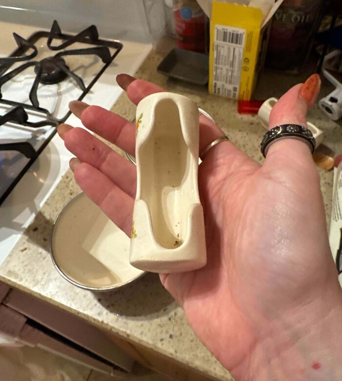 Hand holding a bizarre ceramic item resembling a miniature shoe, one of the most bizarre things people received as Christmas gifts.