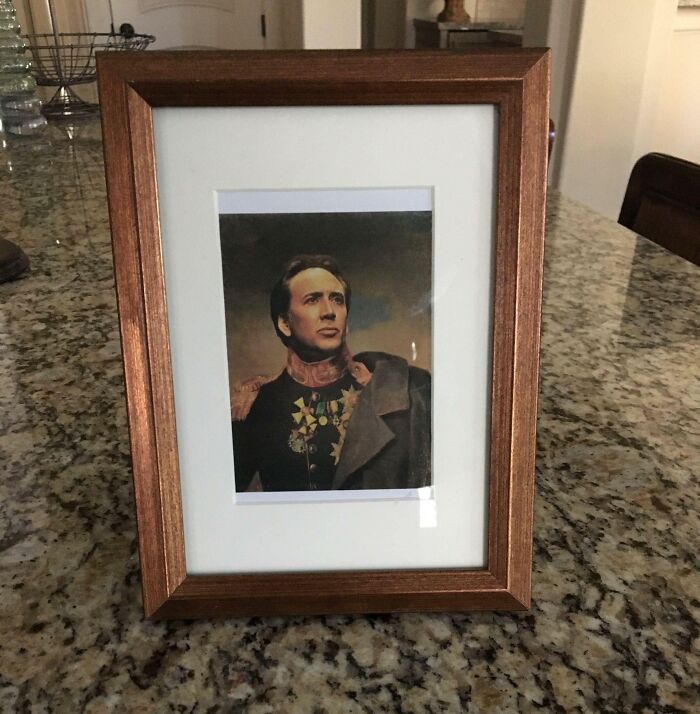 Framed bizarre Christmas gift photo of a man in historical military uniform on a kitchen countertop.