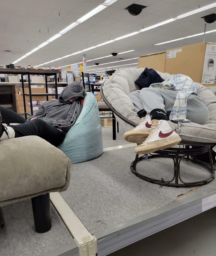 Two people napping on furniture inside a store, illustrating unusual Walmart people moments caught on camera.