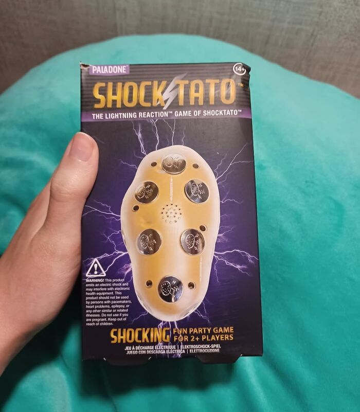 Hand holding Shocktato electronic party game box, featured among best sellers in 2025 delusional trends.