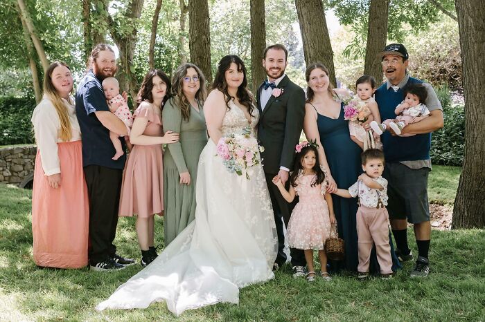 Outdoor wedding portrait of bride, groom, family and children, labeled next-level jerks theme