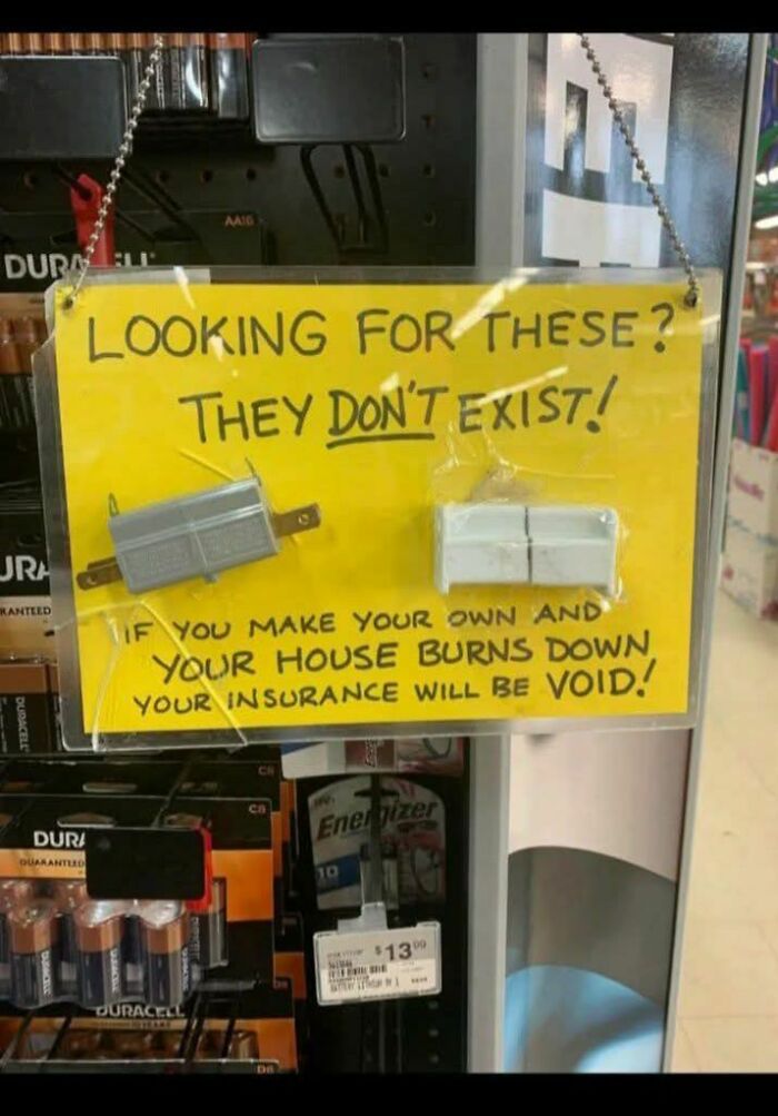 Funny stupid signs pics showing a warning about non-existent electrical parts and insurance risks in a battery display.
