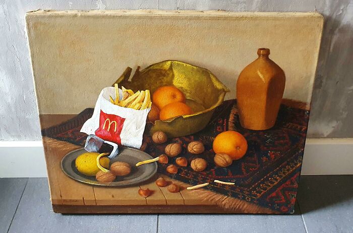 Thrifted painting of still life with oranges and nuts humorously personalized with McDonald's fries and a ketchup packet.