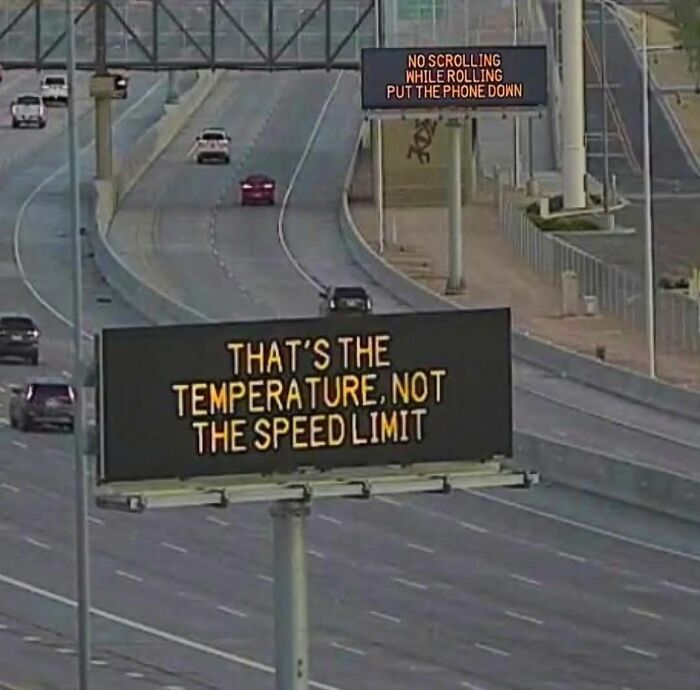 Highway digital sign displaying a funny stupid sign saying temperature is not the speed limit on a busy road.
