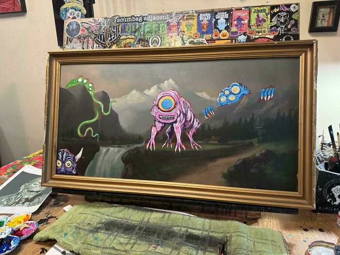 Thrifted painting personalized with funny and unexpected colorful alien creatures added to a mountain landscape scene.