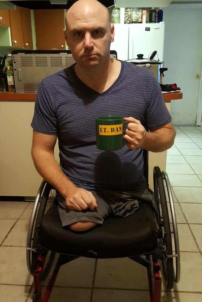 Man in a wheelchair holding a personalized mug, one of the most bizarre things people received as Christmas gifts.
