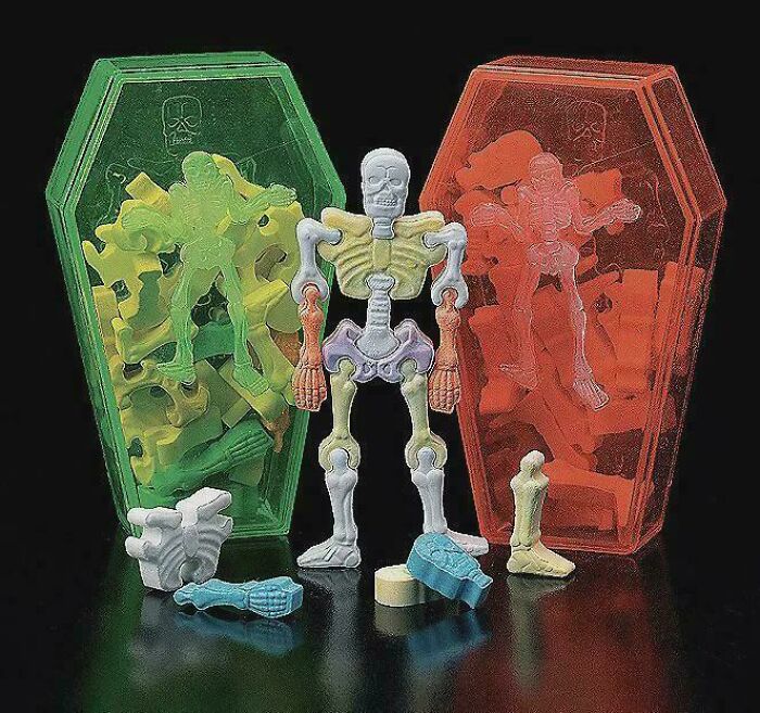 Skeleton puzzle toy with colorful pieces and green and red translucent coffin-shaped containers, evoking 90s and 2000s nostalgia.