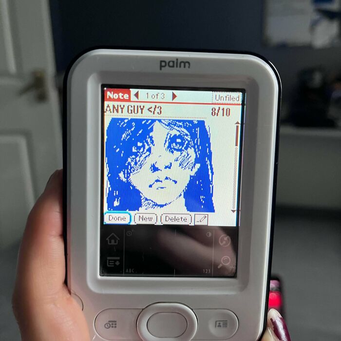 Hand holding a Palm device displaying pixel art of a girl, evoking 90s and 2000s nostalgia memories.