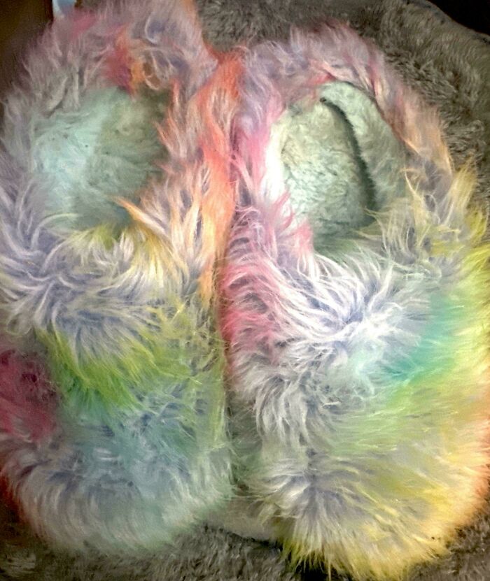 Colorful fuzzy slippers with pink, yellow, green, and blue hues evoking 90s and 2000s nostalgia and childhood memories.