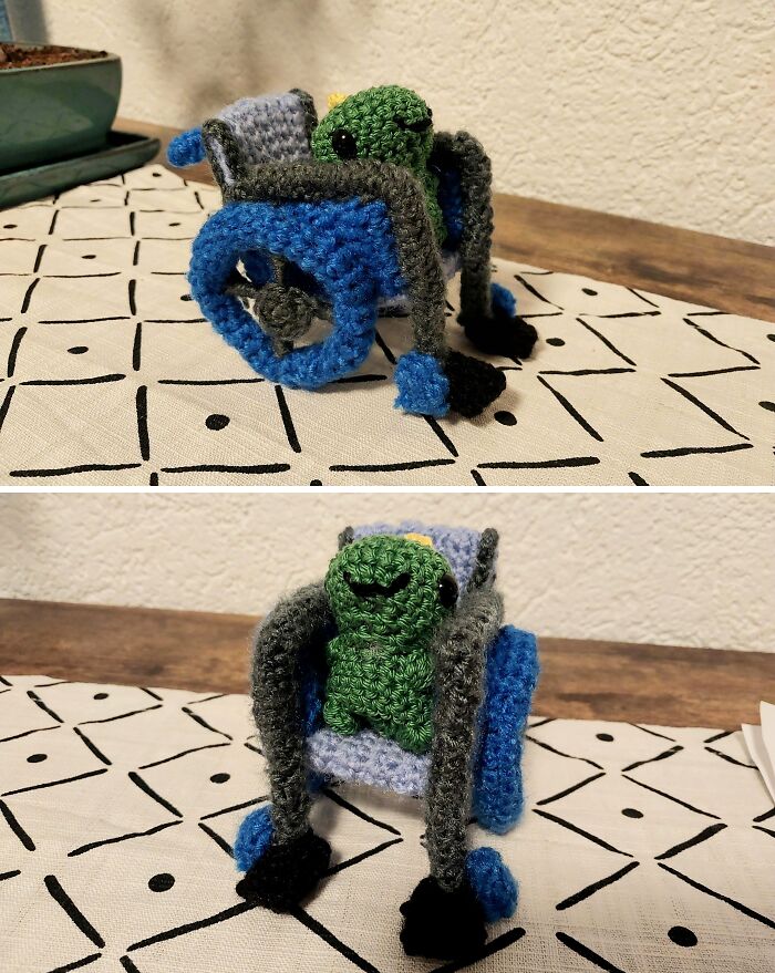 Crocheted green turtle sitting in a blue wheelchair on a patterned cloth, capturing sweet holiday moments.