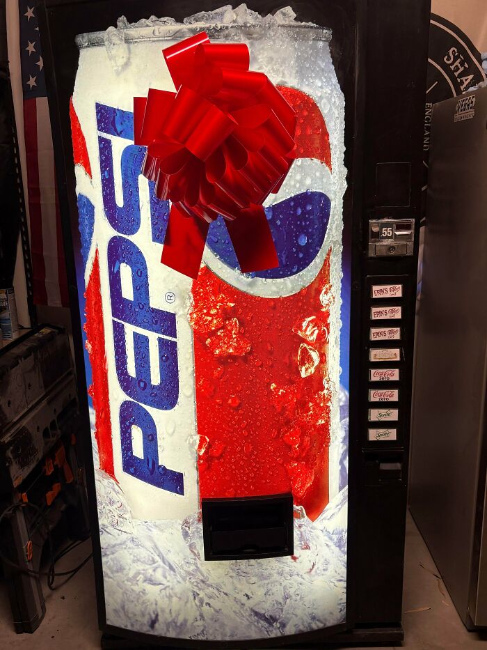 Pepsi vending machine decorated with a festive red bow capturing sweet holiday moments in a cozy indoor setting.