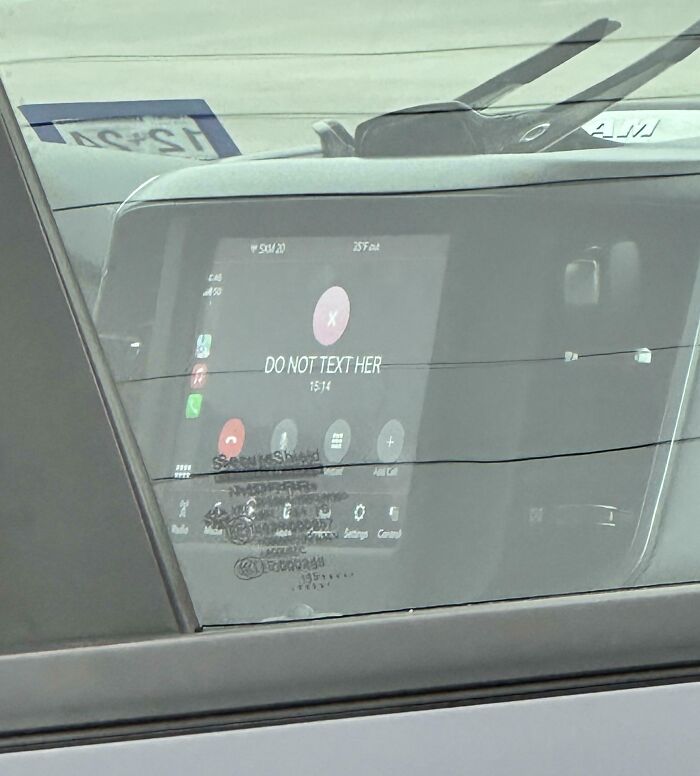Car dashboard screen showing a call with the message DO NOT TEXT HER, capturing a funny picture from 2025 weirdness.