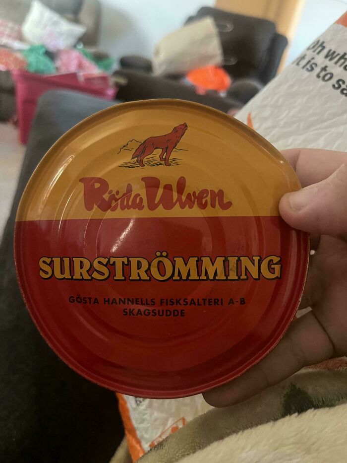 Hand holding a can of surströmming, one of the hilariously bad secret Santa gifts people have actually received.