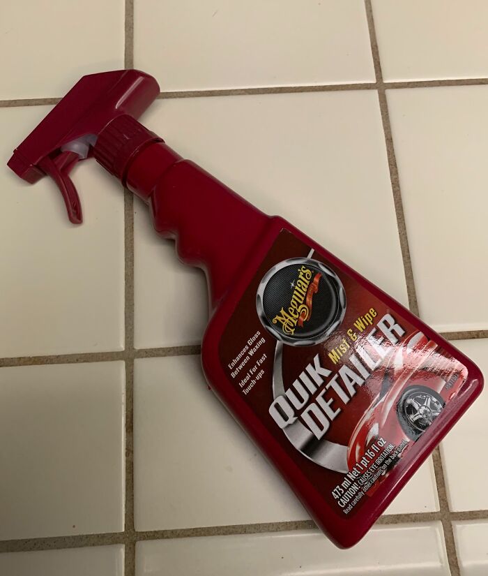 Red spray bottle of Meguiar's Quik Detailer on white tiled floor, an example of bad Secret Santa gifts received.