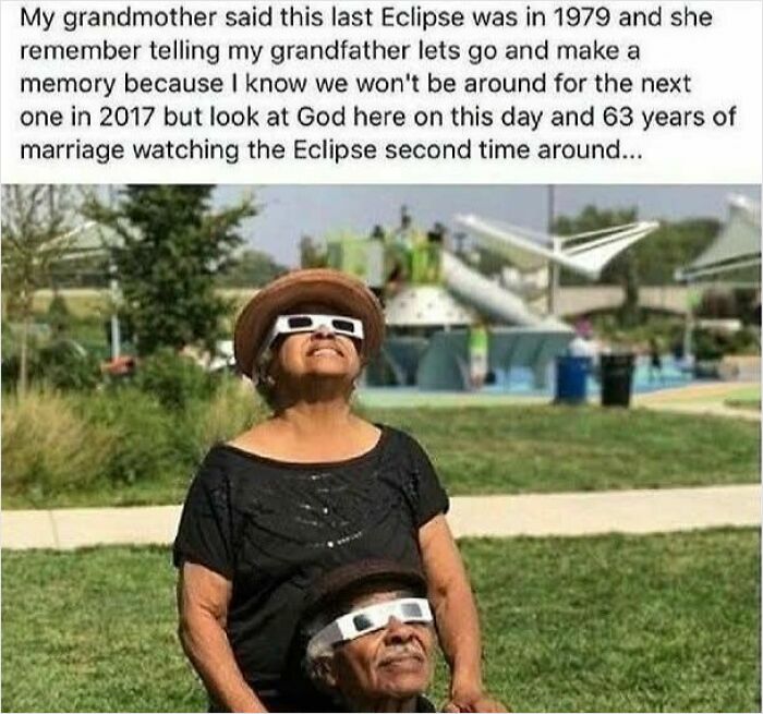 Elderly couple wearing eclipse glasses outdoors, sharing a sweet and wholesome moment during a solar eclipse.