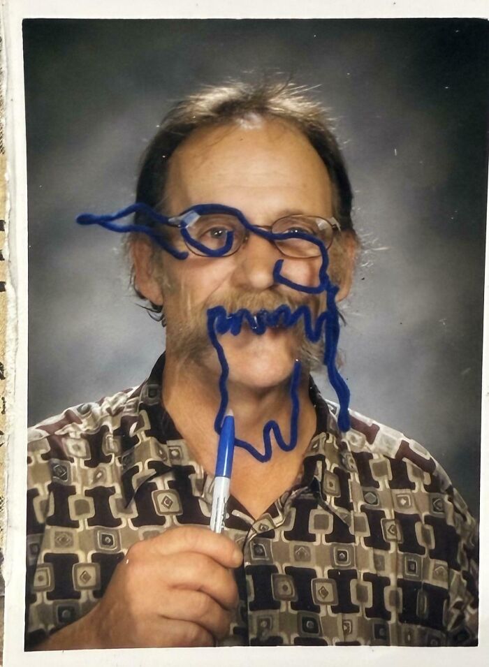 Man holding a blue marker with doodles on his face, showing a funny picture capturing the weirdness of 2025.